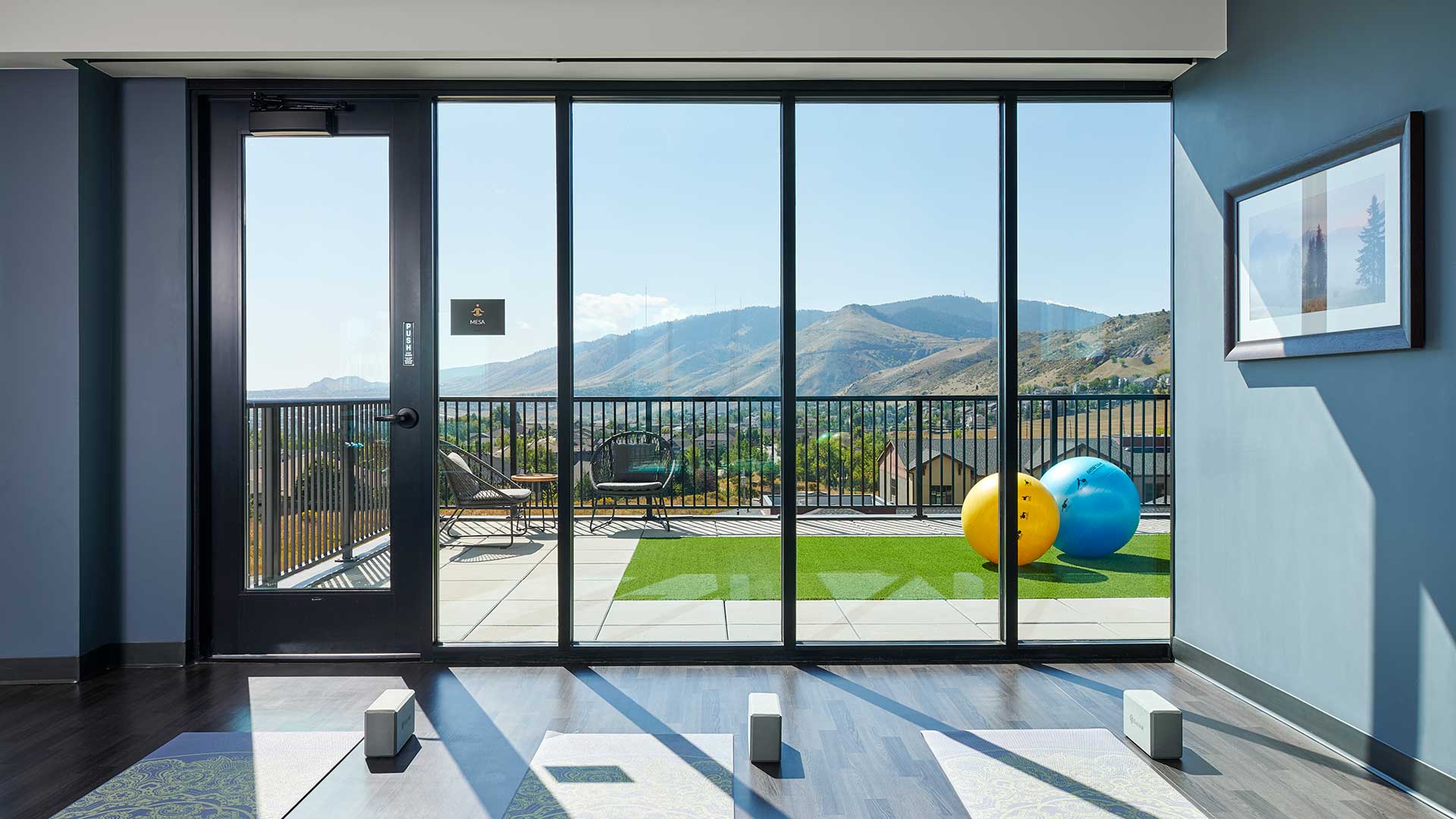 Epoque Golden yoga studio with mats, exercise balls and floor-to-ceiling windows overlooking the foothills.