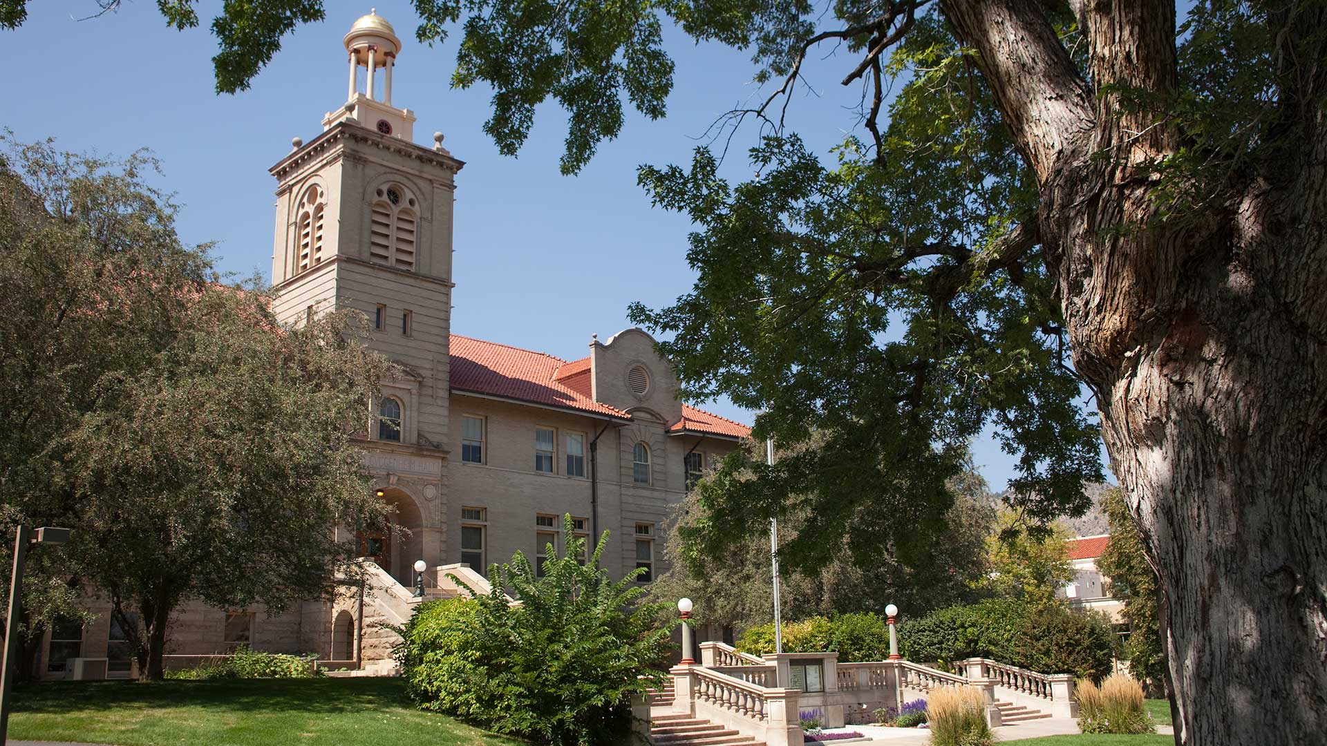 Historic Colorado School of Mines campus building in Golden, Colorado, framed by mature trees and landscaped grounds.