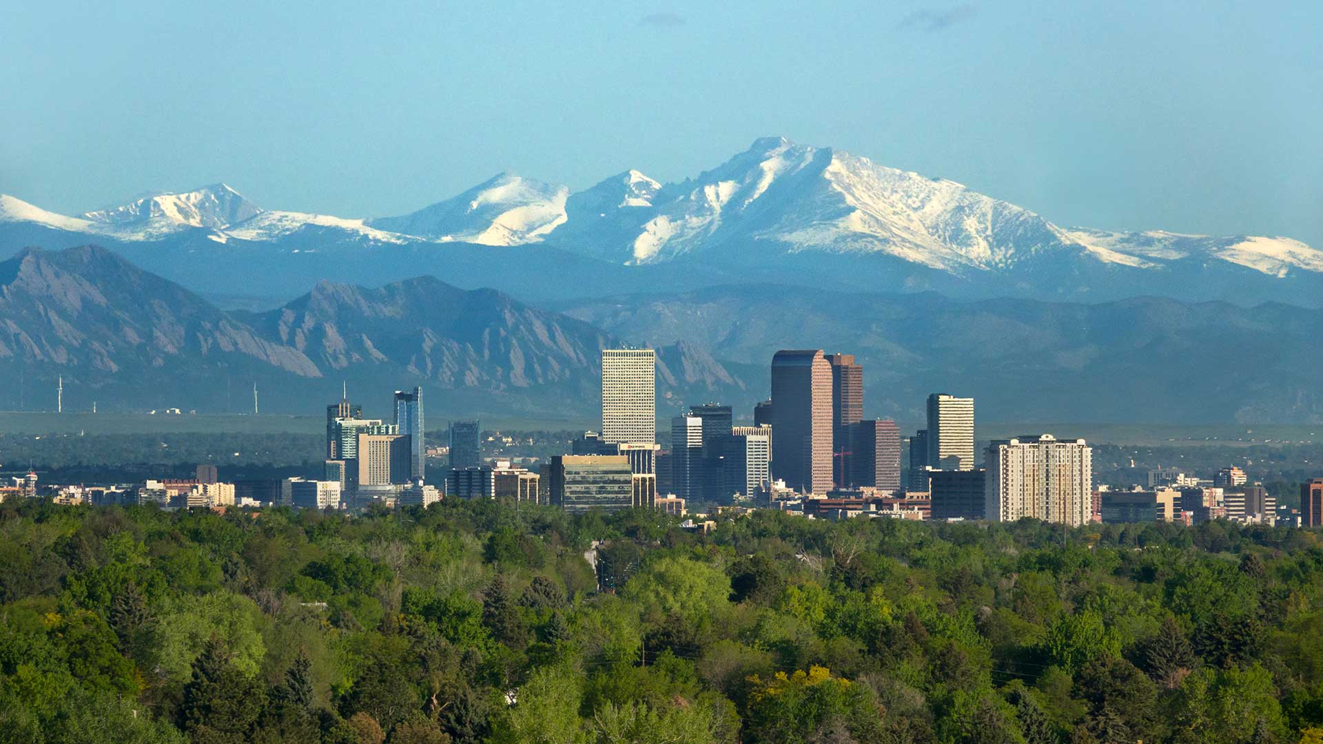 Denver skyline with the snow-covered Rocky Mountains rising in the background.